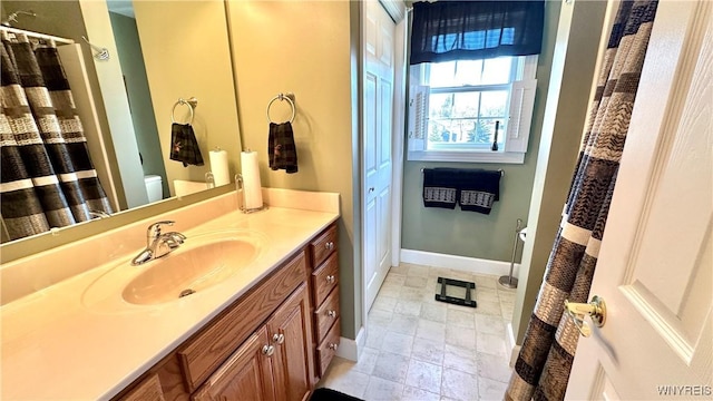 bathroom featuring a shower with shower curtain, baseboards, toilet, and vanity