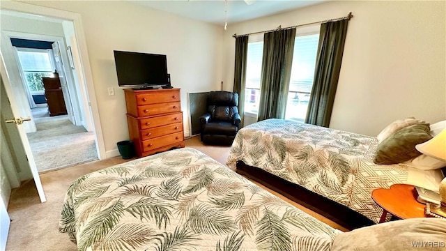 bedroom with baseboards and light carpet