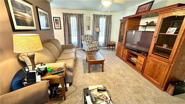 living area featuring light carpet and ceiling fan