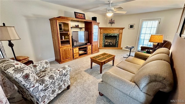 living area featuring baseboards, light carpet, ceiling fan, and a high end fireplace