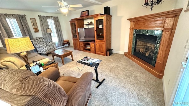 living room with a premium fireplace, light carpet, baseboards, and ceiling fan