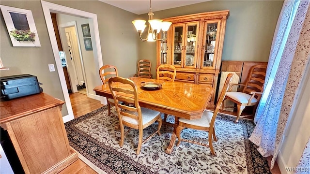 dining space featuring an inviting chandelier and wood finished floors