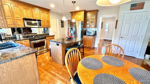 kitchen with light wood-style flooring, a center island, visible vents, and stainless steel appliances