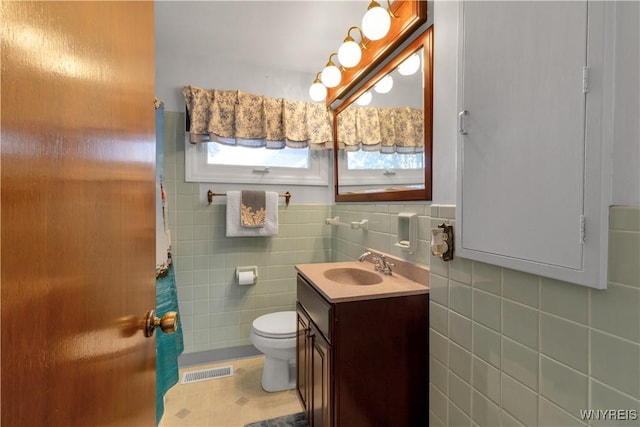 bathroom featuring visible vents, toilet, a shower with curtain, tile walls, and vanity