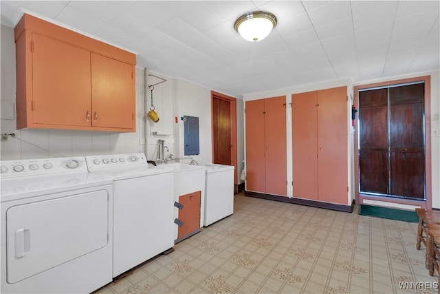 laundry room with cabinet space, independent washer and dryer, light floors, and electric panel