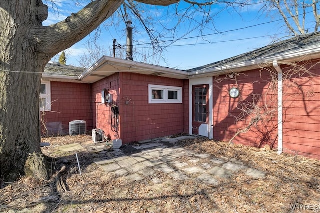 rear view of property with central AC