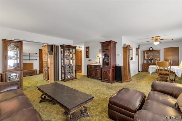 living room with light carpet, visible vents, and a ceiling fan