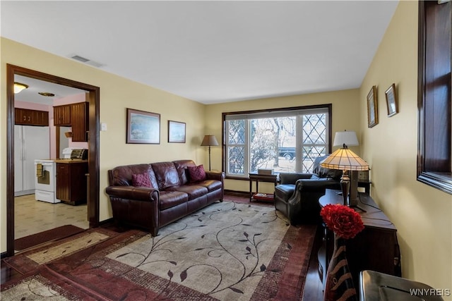 living room featuring tile patterned floors, visible vents, and baseboards