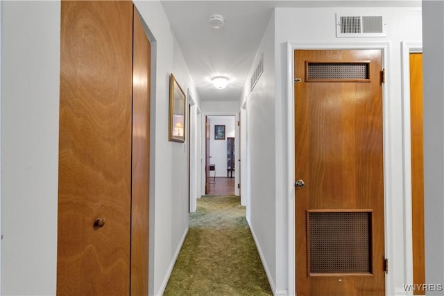 corridor with visible vents, baseboards, and carpet