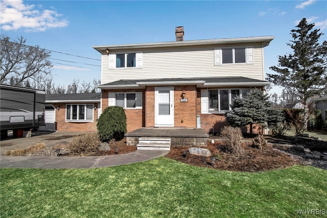 view of front facade featuring a front lawn, brick siding, and a chimney