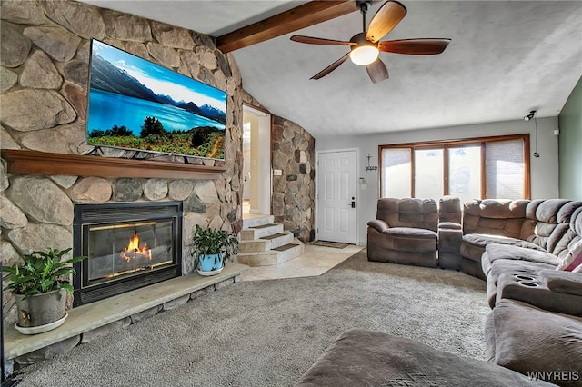 living room with a stone fireplace, carpet flooring, vaulted ceiling with beams, and a ceiling fan