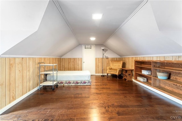 unfurnished bedroom with wood finished floors, lofted ceiling, and wood walls