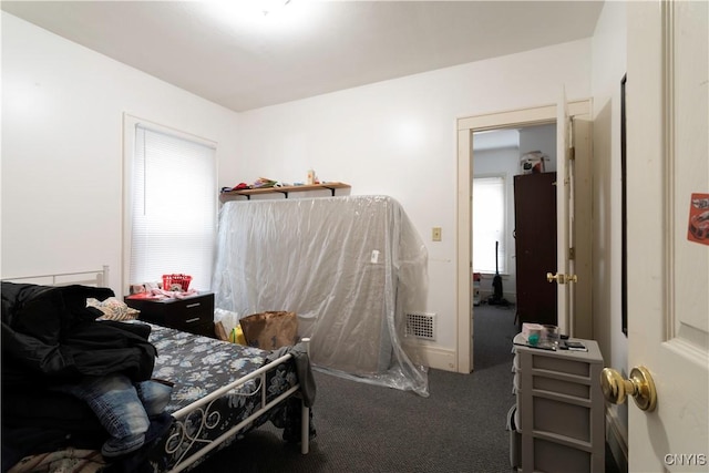 bedroom with visible vents, multiple windows, and carpet flooring