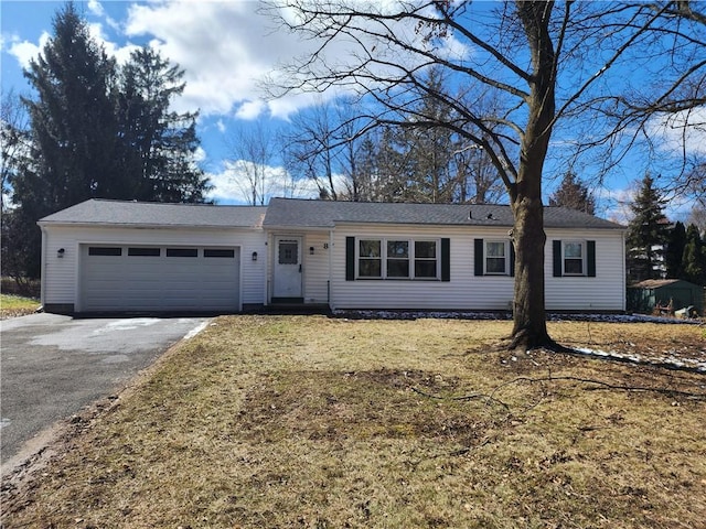 single story home featuring an attached garage, driveway, and a front yard