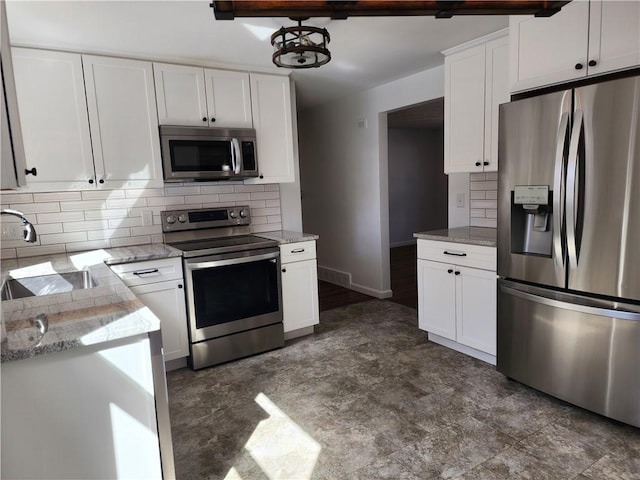 kitchen with decorative backsplash, white cabinetry, stainless steel appliances, and a sink