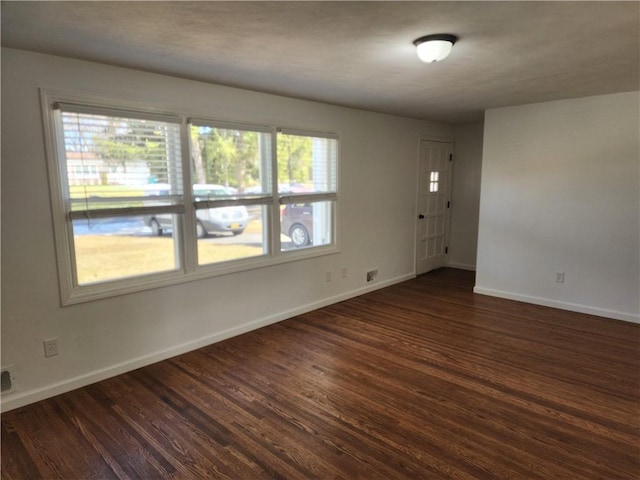 unfurnished room with dark wood-style floors and baseboards