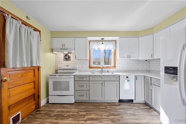 kitchen with a sink, visible vents, white appliances, and light countertops