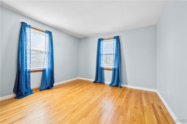 empty room with visible vents, baseboards, and wood finished floors