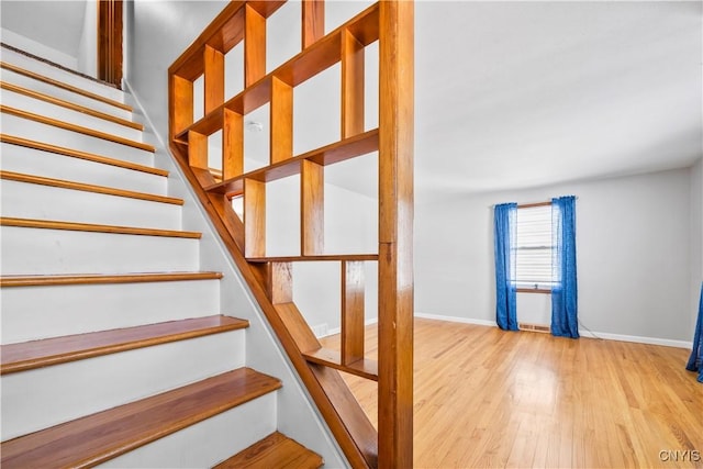 stairway featuring baseboards and wood finished floors