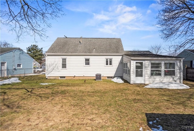 rear view of property featuring fence, roof with shingles, central AC unit, a yard, and a patio