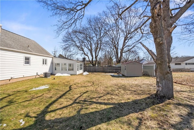 view of yard with an outbuilding, a storage shed, central AC, and a fenced backyard