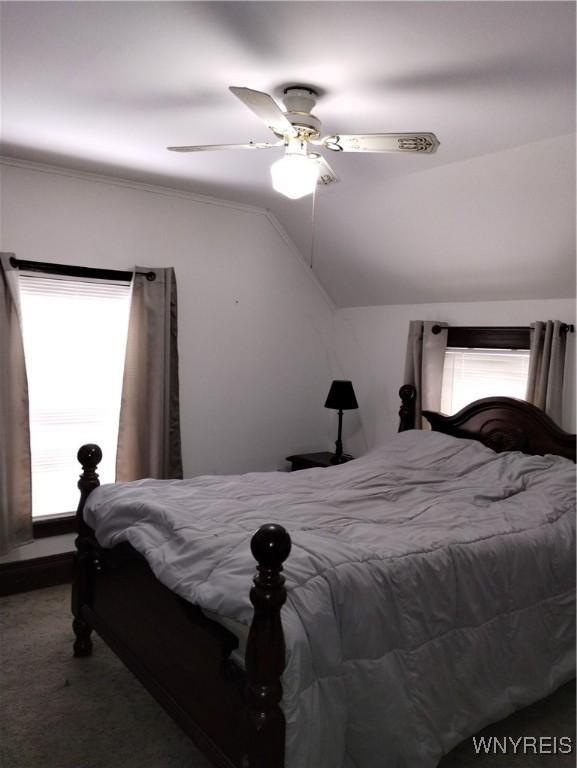 bedroom with carpet flooring, ceiling fan, and vaulted ceiling