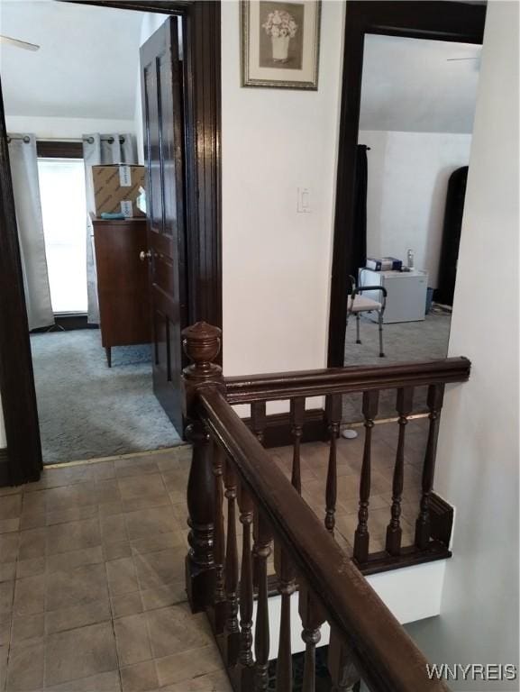 hallway featuring an upstairs landing and carpet