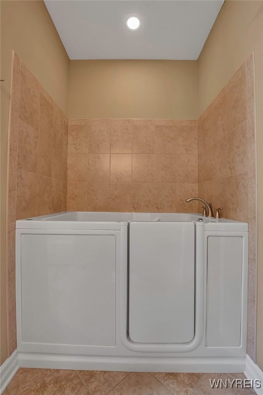 bathroom with tile patterned floors and a tub