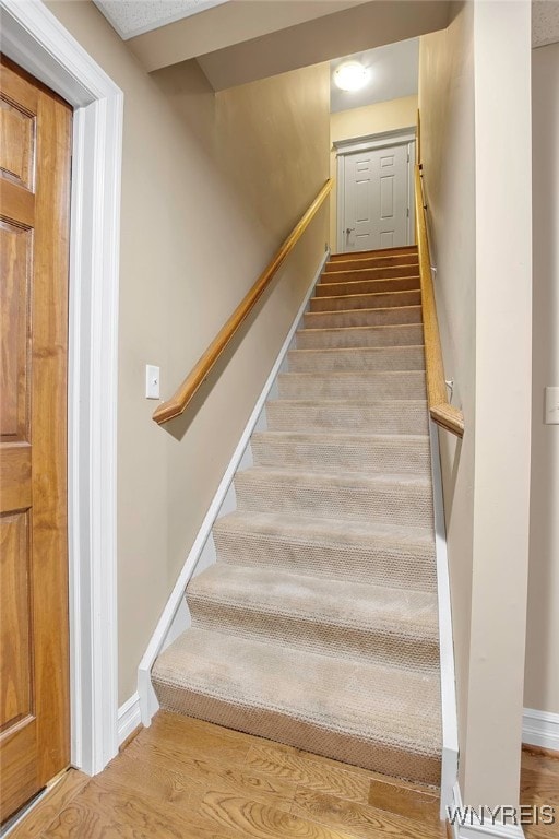 staircase with wood finished floors and baseboards