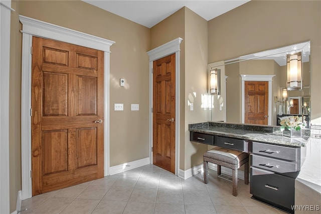 bathroom featuring baseboards, vanity, and tile patterned flooring