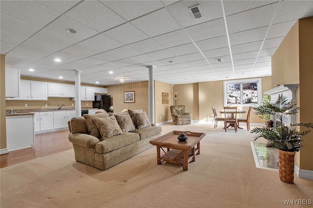 living area with recessed lighting, visible vents, light colored carpet, and baseboards