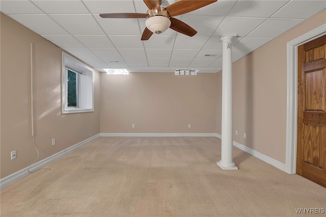 basement featuring visible vents, baseboards, ceiling fan, light colored carpet, and a paneled ceiling