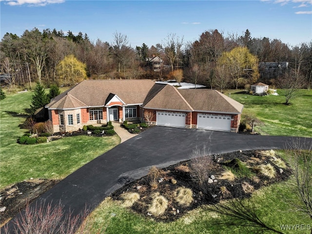 view of front of house with a front yard, an attached garage, and driveway