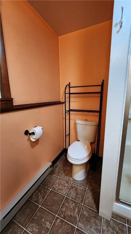 bathroom with baseboards, a baseboard radiator, a shower stall, tile patterned floors, and toilet