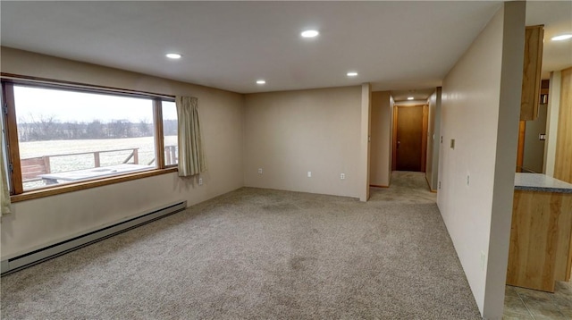 empty room featuring recessed lighting, a baseboard heating unit, and light colored carpet