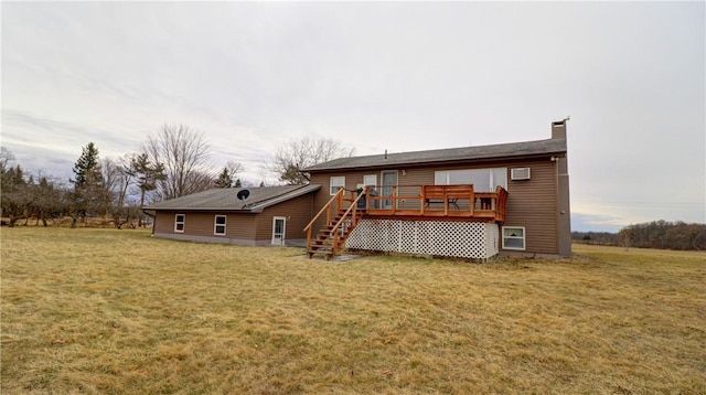 back of house featuring a lawn, a chimney, a deck, and stairs