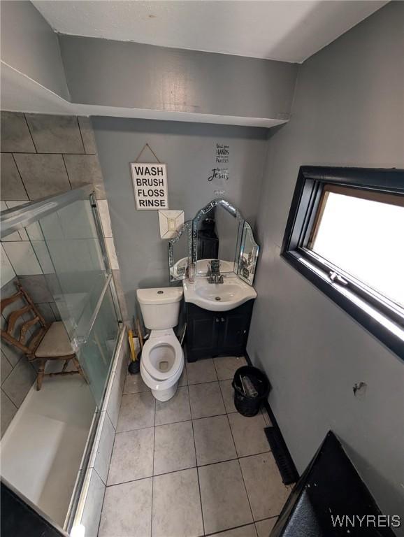 full bathroom with tile patterned flooring, a shower stall, toilet, and vanity