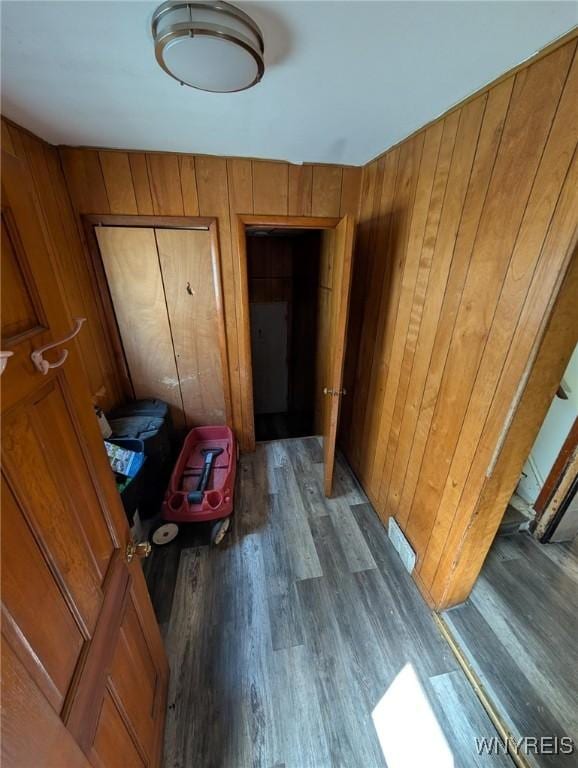 hall featuring wood finished floors and wood walls