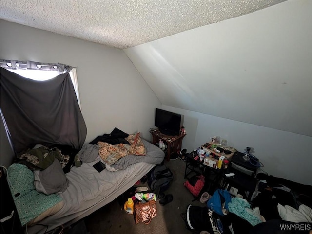 bedroom featuring lofted ceiling and a textured ceiling