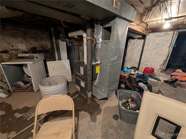 unfinished basement with heating unit, gas water heater, and washer / clothes dryer