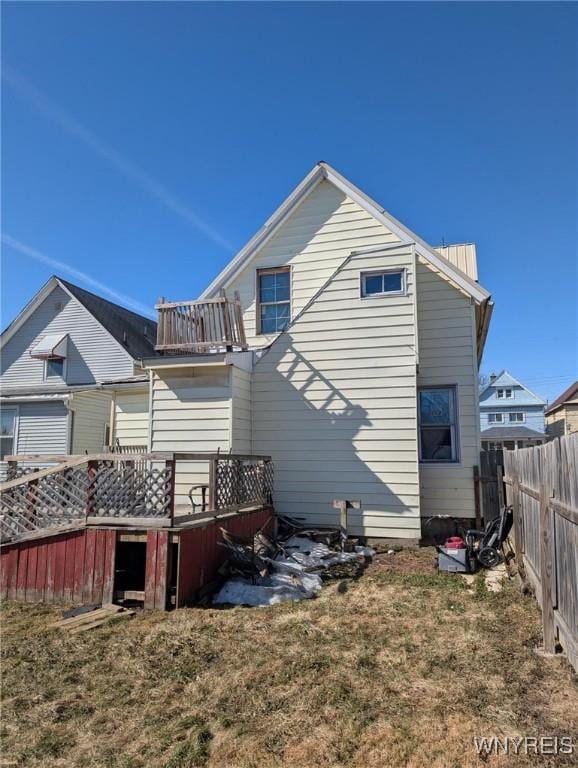 back of property featuring a wooden deck and fence