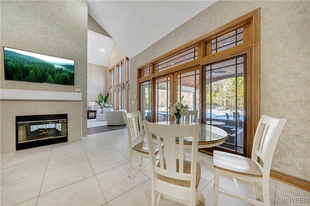 dining room with a fireplace and high vaulted ceiling