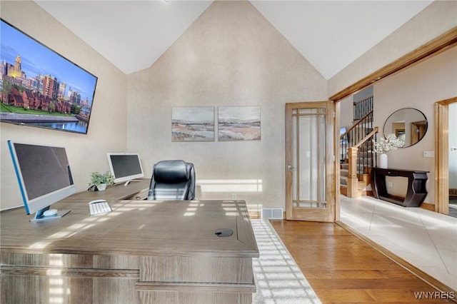 office area featuring visible vents, high vaulted ceiling, and wood finished floors