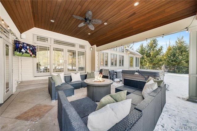 view of patio with french doors, an outdoor living space with a fire pit, a ceiling fan, and a hot tub