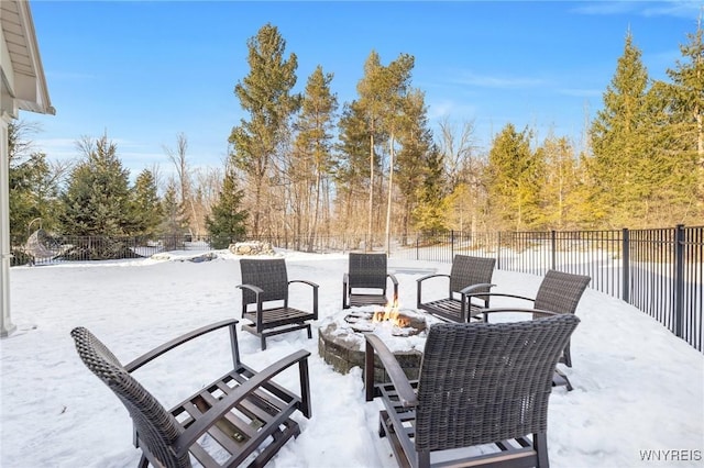 snow covered patio featuring fence and an outdoor fire pit