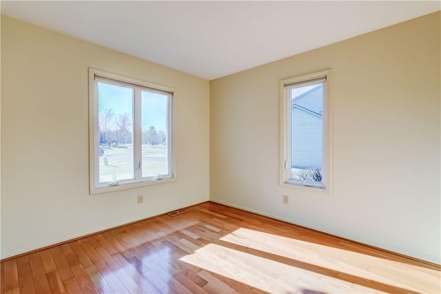 spare room featuring visible vents and wood finished floors