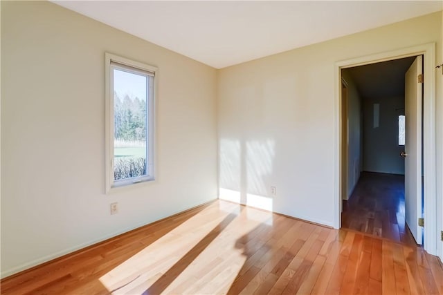 empty room with light wood-style flooring and baseboards