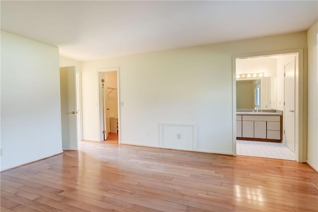 unfurnished room featuring light wood finished floors and a sink