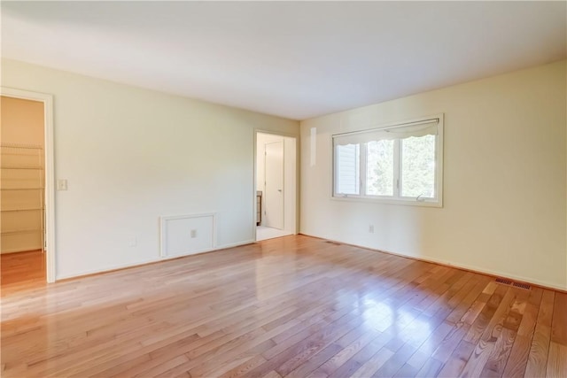 unfurnished room featuring wood finished floors and visible vents