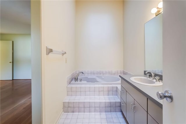 full bathroom with a garden tub, vanity, and tile patterned flooring